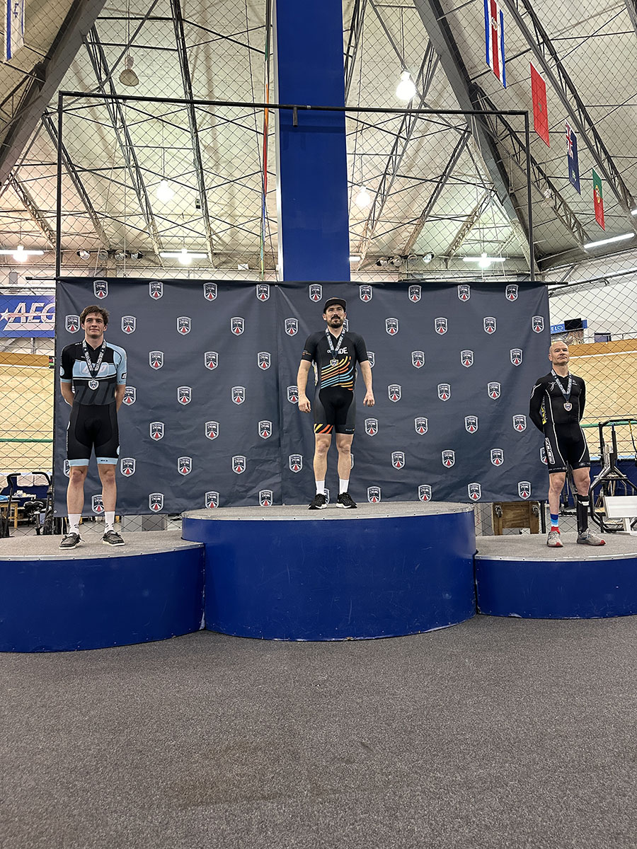 Steven on the top step of a national championship podium, wearing a paracycling jersey