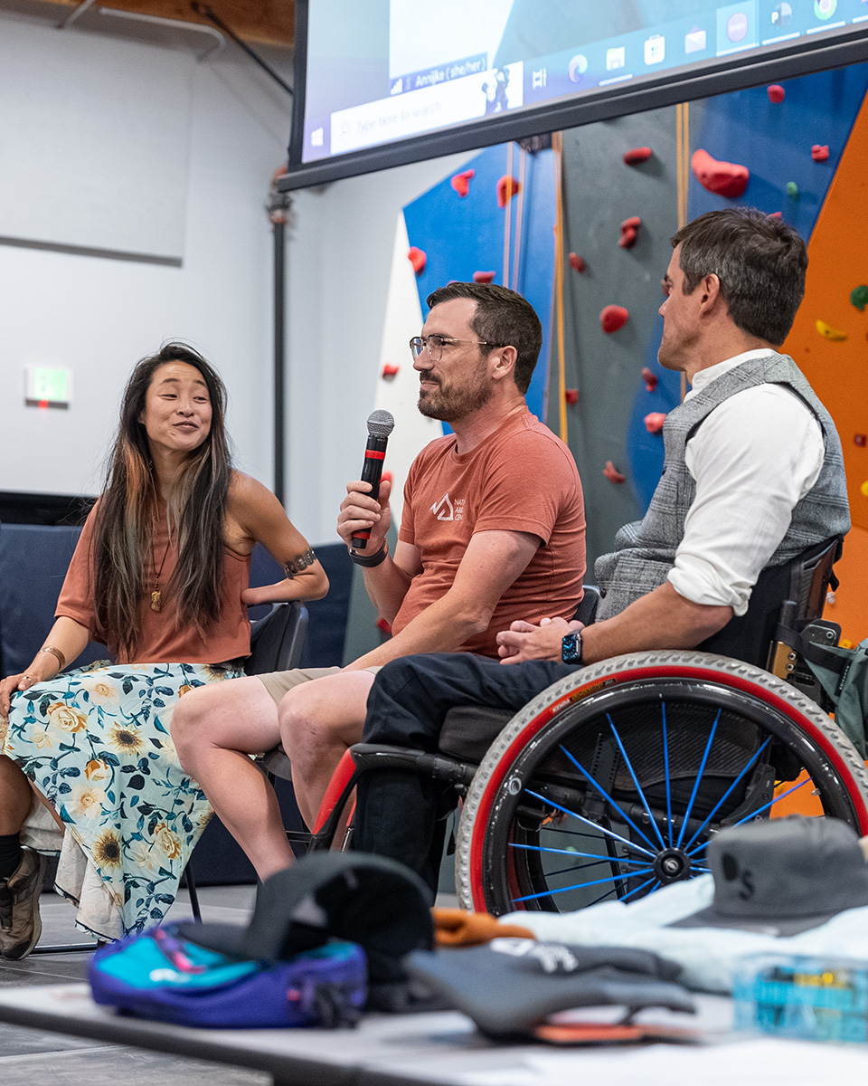 Steven speaking with a microphone on a panel at the National Ability Center